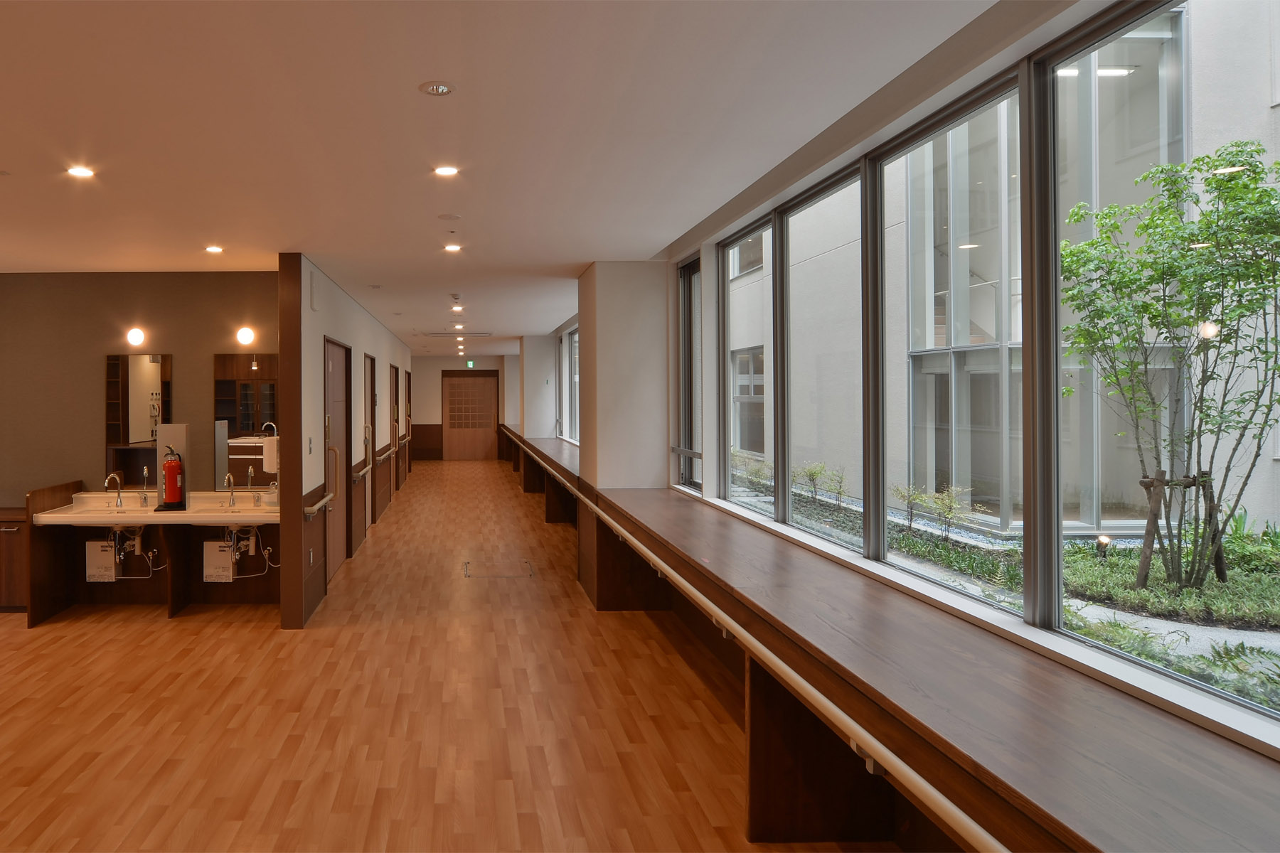 Nabari Intensive Nursing Home Courtyard enclosed by a corridor flooded with natural light.