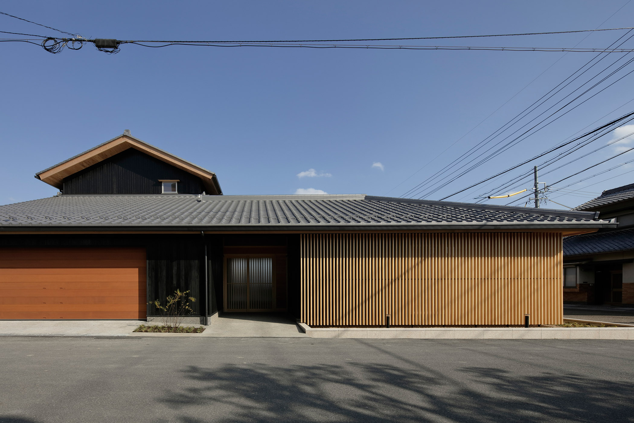 住居の玄関とオフィスと面格子のコントラスト