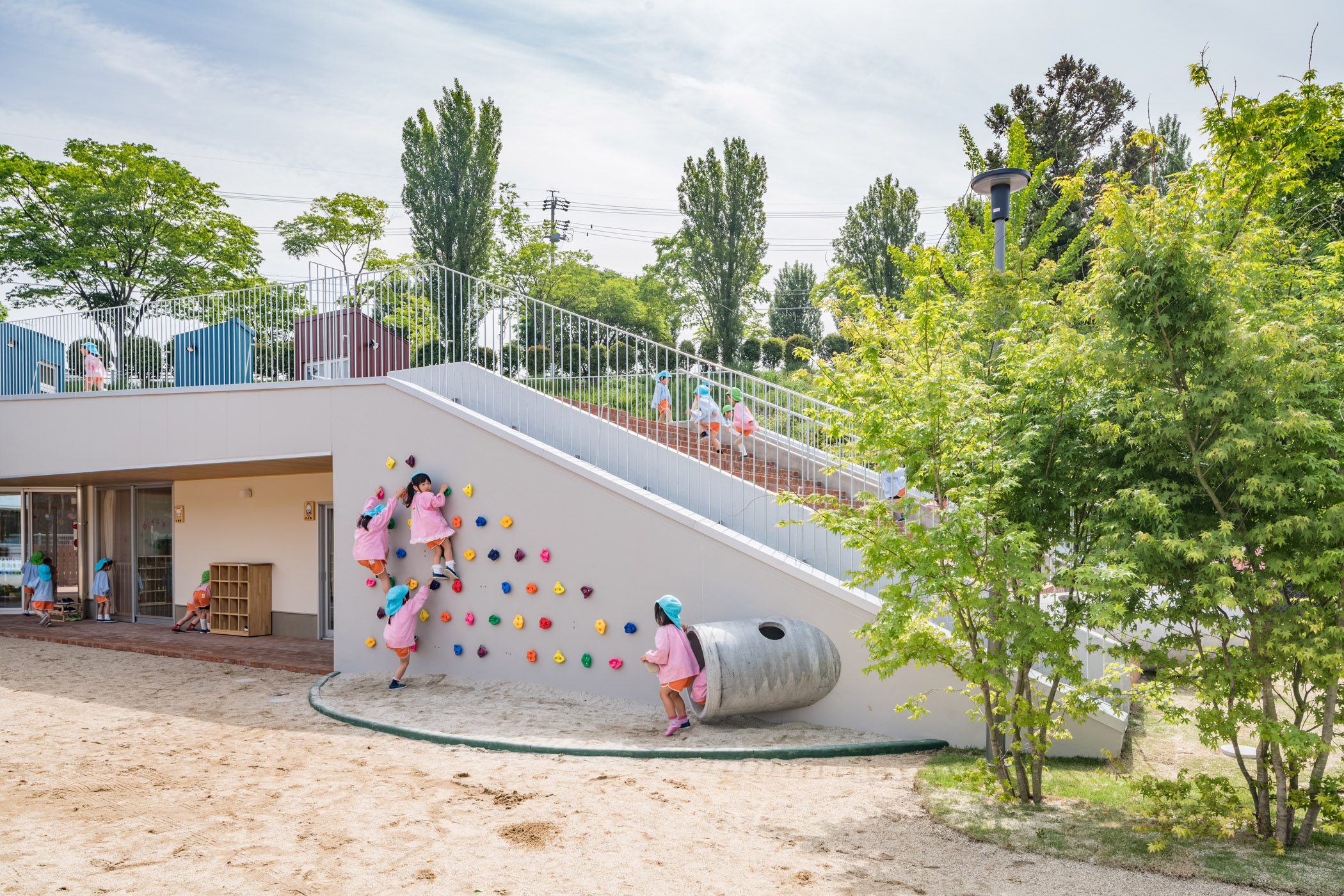 ボルダリング・土管で遊ぶ園児たち。園児たちがこの建築で過ごすことではじめて完成となる